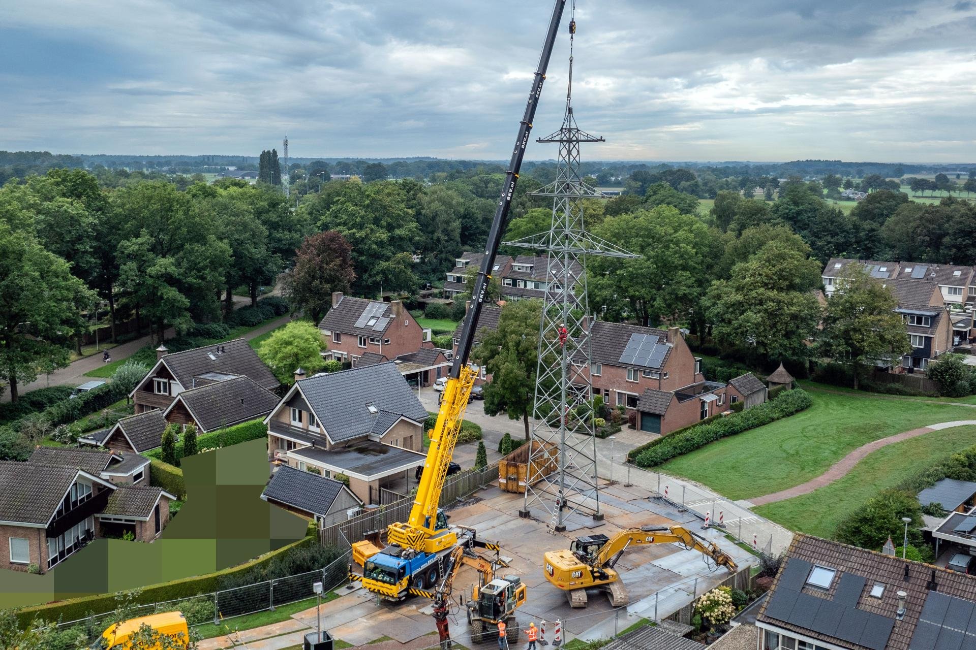 Overzicht van de kraan naast de hoogspanningsmast